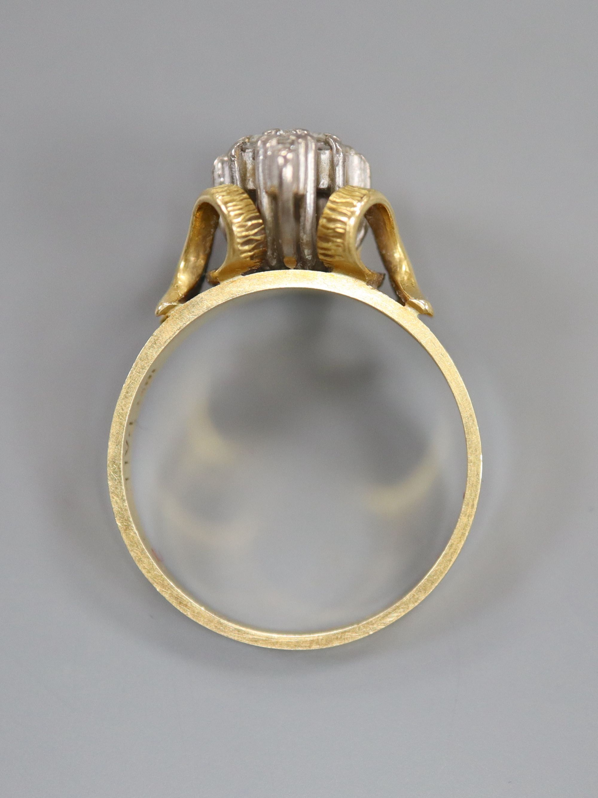 An 18ct and diamond cluster dress ring, in a raised setting, size Q/R, gross 5.9 grams.